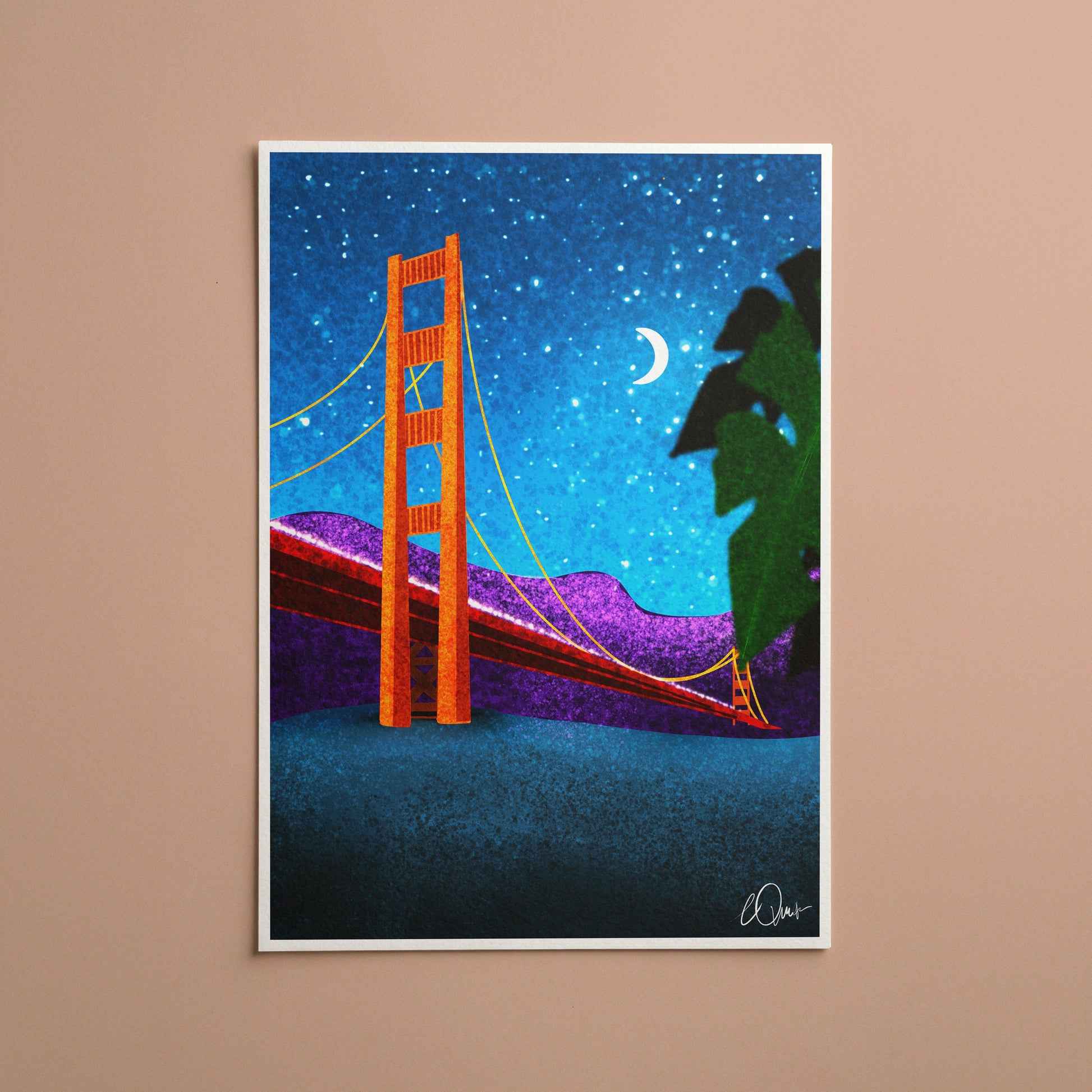 Framed artwork of the Golden Gate Bridge under a starry night sky on a beige wall.